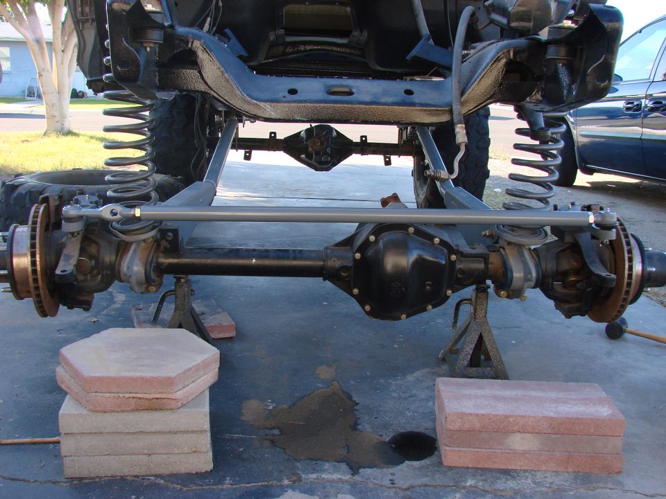 Front solid axle with coil springs and tie rod under a lifted 4x4 truck