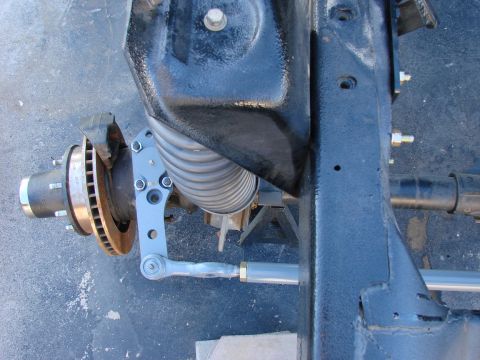 1979 Ford Bronco - Detail of a vehicle's front suspension system, including brake components and steering linkage.
