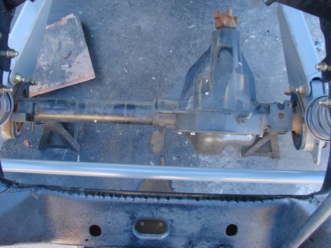 1979 Ford Bronco - Close-up view of a vehicle's front axle assembly, supported by jack stands.