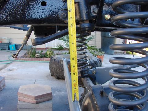 1979 Ford Bronco - A tape measure is used to gauge the height of a vehicle's suspension component.