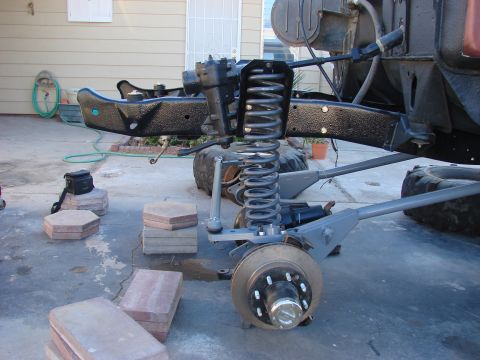 1979 Ford Bronco - Close-up of a vehicle's front suspension system, showing the coil spring and brake components.