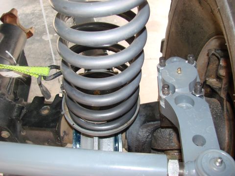 1979 Ford Bronco - This image shows a close-up view of a vehicle's front suspension system, focusing on the coil spring and steering components.