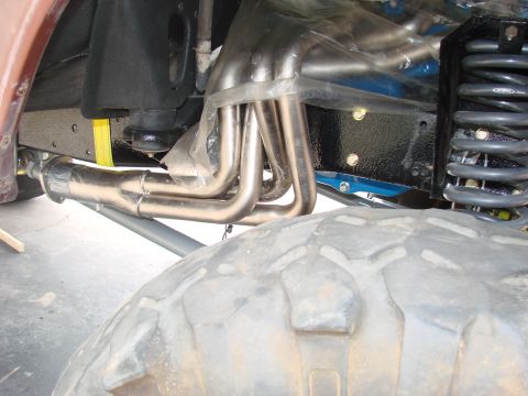 1979 Ford Bronco - Close-up view of exhaust headers and suspension parts, not clearly identifiable as a specific vehicle model or year.