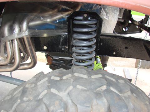 1979 Ford Bronco - Front suspension coil spring and exhaust headers are visible in this close-up shot.