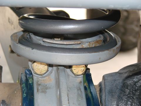 1979 Ford Bronco - Close-up of a vehicle's suspension system, focusing on a coil spring and mounting hardware.