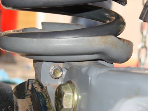 1979 Ford Bronco - This image shows a close-up view of a vehicle's front suspension component, focusing on the coil spring mount.