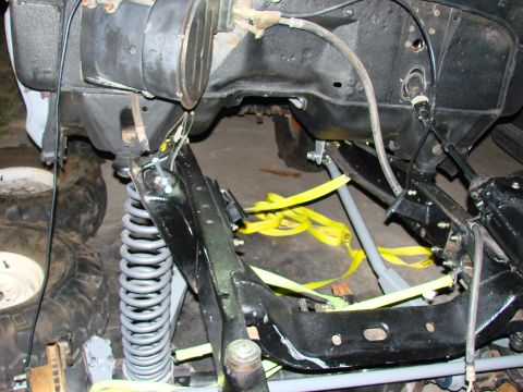 1979 Ford Bronco - The underside of a vehicle is shown, focusing on the frame and suspension system during what appears to be maintenance or repair.