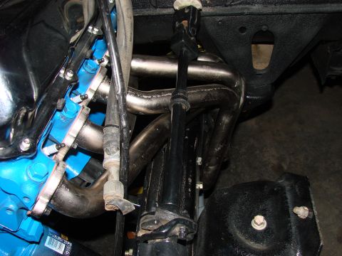 1979 Ford Bronco - This image shows a close-up view of an engine's exhaust manifold and steering components.