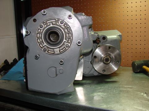 1979 Ford Bronco - Gray NP203/205 doubler transfer case shown on a workbench with a circular flange on the right side.