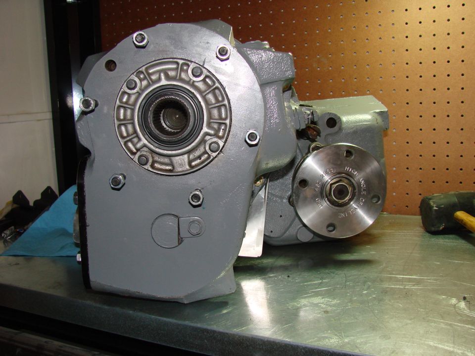 Gray transfer case with splined output and machined flange hub on a workbench