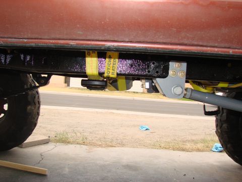 1979 Ford Bronco - Vehicle frame detail with suspension components and tie-down straps visible.