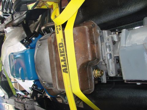 1979 Ford Bronco - The vehicle's drivetrain components are secured with yellow lifting straps during maintenance or installation.