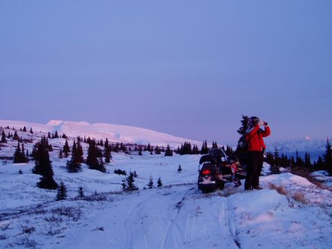 2000 Ford E350 - Winter scene with a snowmobile and a person observing the landscape at dusk.