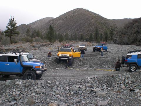 2007 Toyota FJ Cruiser - Multiple Toyota FJ Cruisers are seen off-roading in a , mountainous terrain.