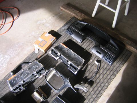 1994 Ford Bronco - Various car interior parts are disassembled and laid out on a mat on the floor.