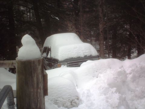 1966 Land Rover Discovery - A vehicle is almost completely covered by a thick layer of snow, with only the grille and part of the hood visible.