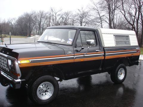 1979 Ford F-150 - This 1979 Ford F-150 pickup truck is equipped with a camper shell and distinctive side striping.