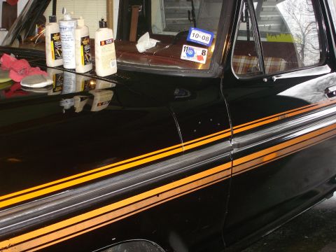 1979 Ford F-150 - A black 1979 Ford F-150 pickup truck is detailed, with bottles of polish and rags on the hood.