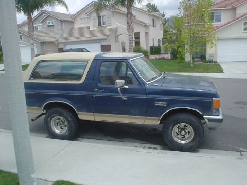 1986 Ford Bronco - This 1986 Ford Bronco, seen from the side, features a two-tone blue and tan paint scheme.