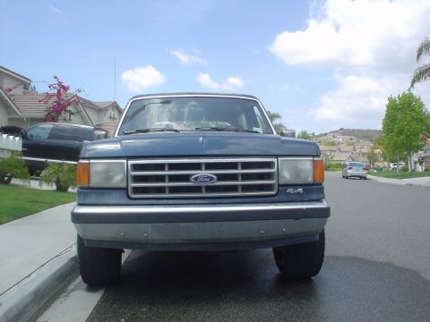 1986 Ford Bronco - This Ford F-Series truck has a prominent grille with the Ford logo and a 4x4 badge on the lower right side.