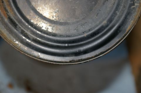 1986 Ford Bronco - Close-up of a weathered metal rim, showing signs of age and wear with distinct concentric ridges.