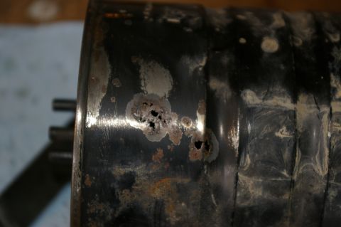 1986 Ford Bronco - Close-up of a corroded metal cylinder, indicating significant age and exposure to elements.