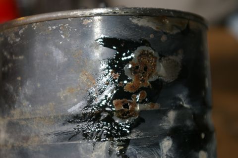 1986 Ford Bronco - This part shows significant damage with rust and what appears to be burnt residue.