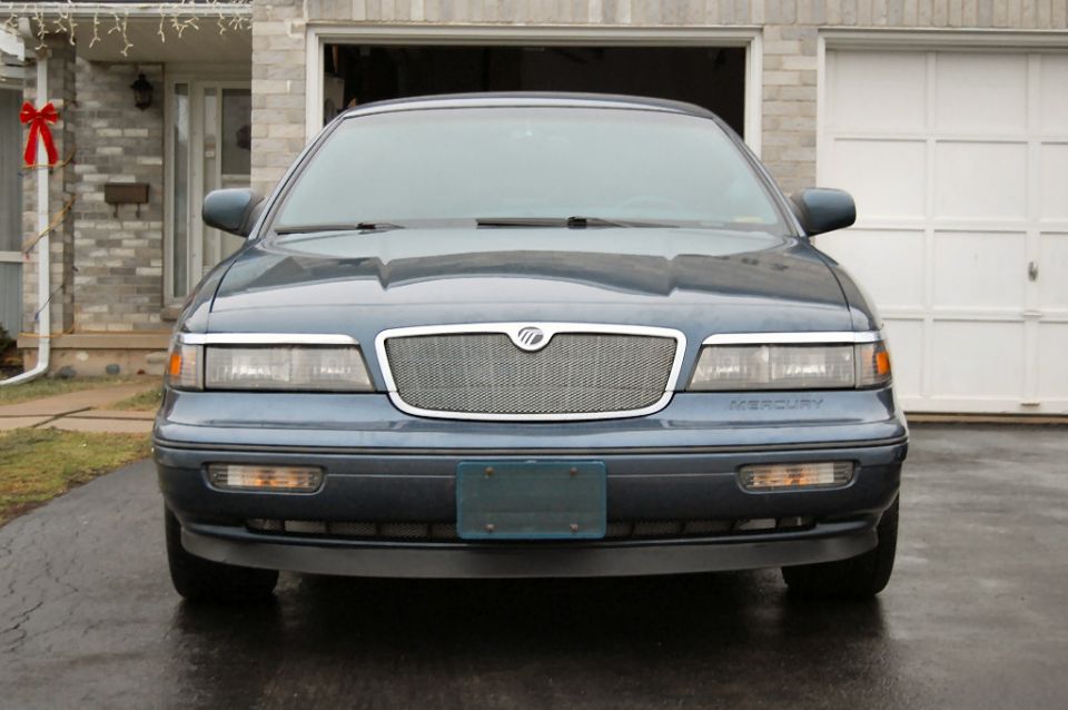 Front view of a blue Mercury Grand Marquis parked in a driveway