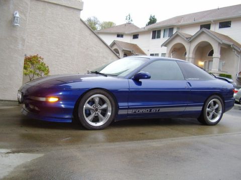 1994 Ford Probe - A blue Ford Probe is seen from the side, parked in front of a residential building.