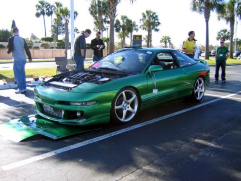 1994 Ford Probe - A custom green 1994 Ford Probe is displayed with its hood open, revealing the engine bay.