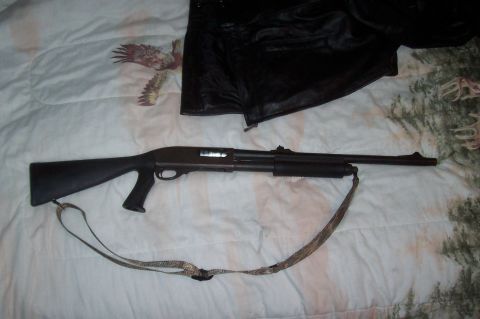 1994 Ford F-150 - A shotgun is displayed on a comforter, with a black jacket partially visible.