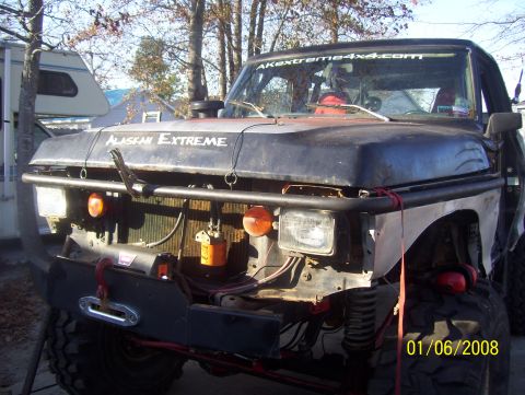 1978 Ford Bronco - Front view of a modified black Ford truck with "Alaskan Extreme" text on the hood and a winch mounted on the bumper.