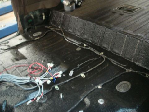 1996 Ford Bronco - Wiring harness components are visible on the black textured floor of a vehicle interior.