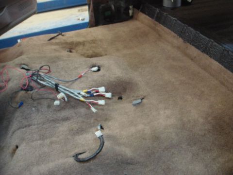 1996 Ford Bronco - Exposed wiring harness and connectors on vehicle interior carpet.