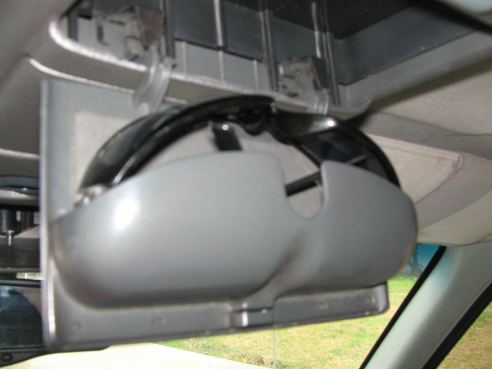 Sunglasses stored in a gray overhead console inside a vehicle