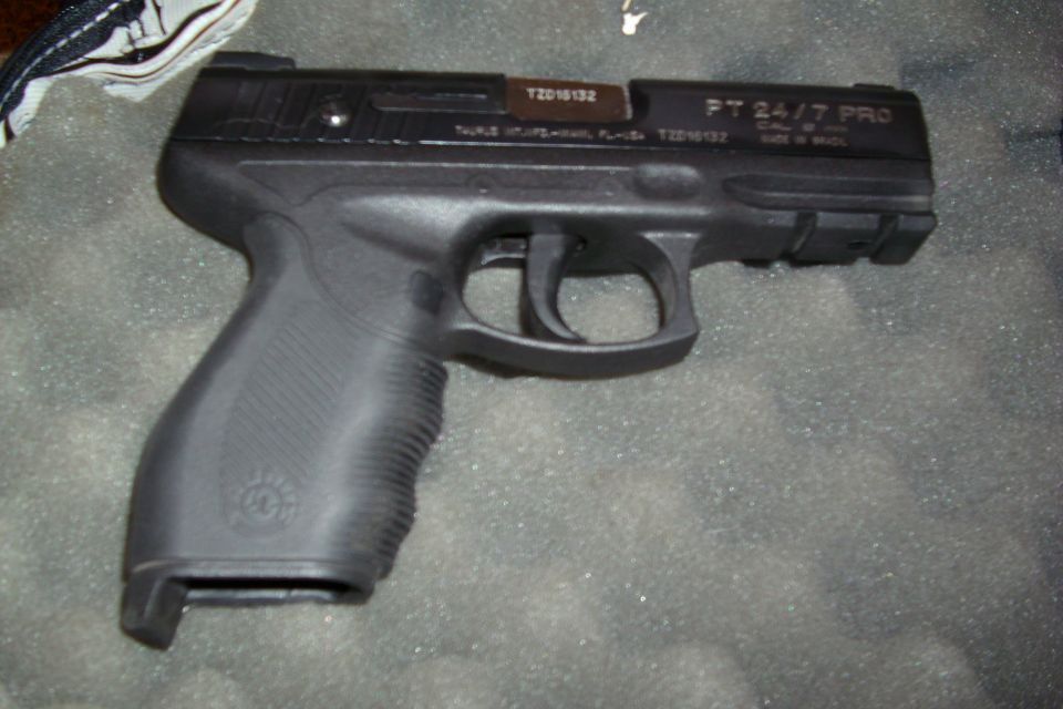 Black Taurus PT 24/7 Pro pistol on carpet showing slide markings