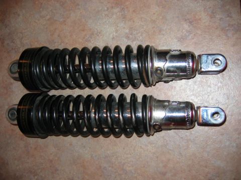 1985 Ford LTD Crown Victoria - A pair of adjustable coil-over shock absorbers are shown, with visible text on the black spring housings.