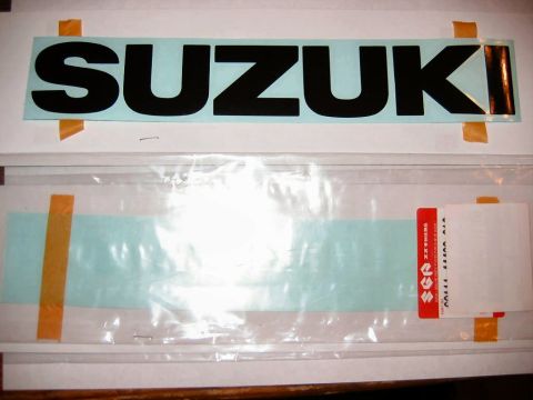 1985 Ford LTD Crown Victoria - Suzuki decal and a second decal with red Suzuki logo in packaging.