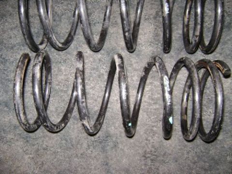 1991 Ford Taurus - Close-up view of used vehicle coil springs, showing wear and some identifying marks.