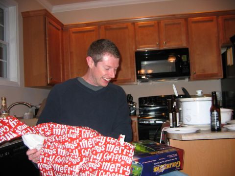 1985 Ford LTD Crown Victoria - Man opening a Christmas gift in a kitchen setting.