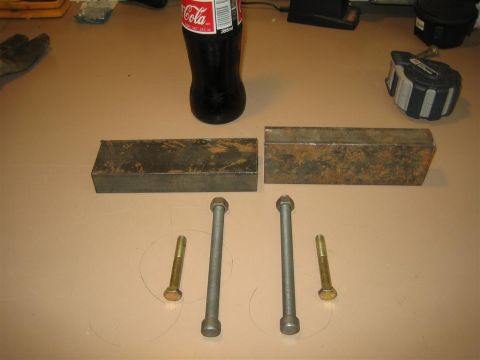 1987 Suzuki Samurai - Various metal parts, including brackets and bolts, are arranged on a surface next to a bottle of Coca-Cola.