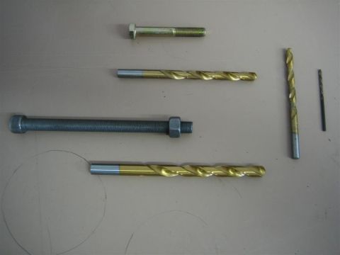 1987 Suzuki Samurai - Various bolts and drill bits are laid out on a surface, with a Supermotors.net logo visible in the lower right corner.