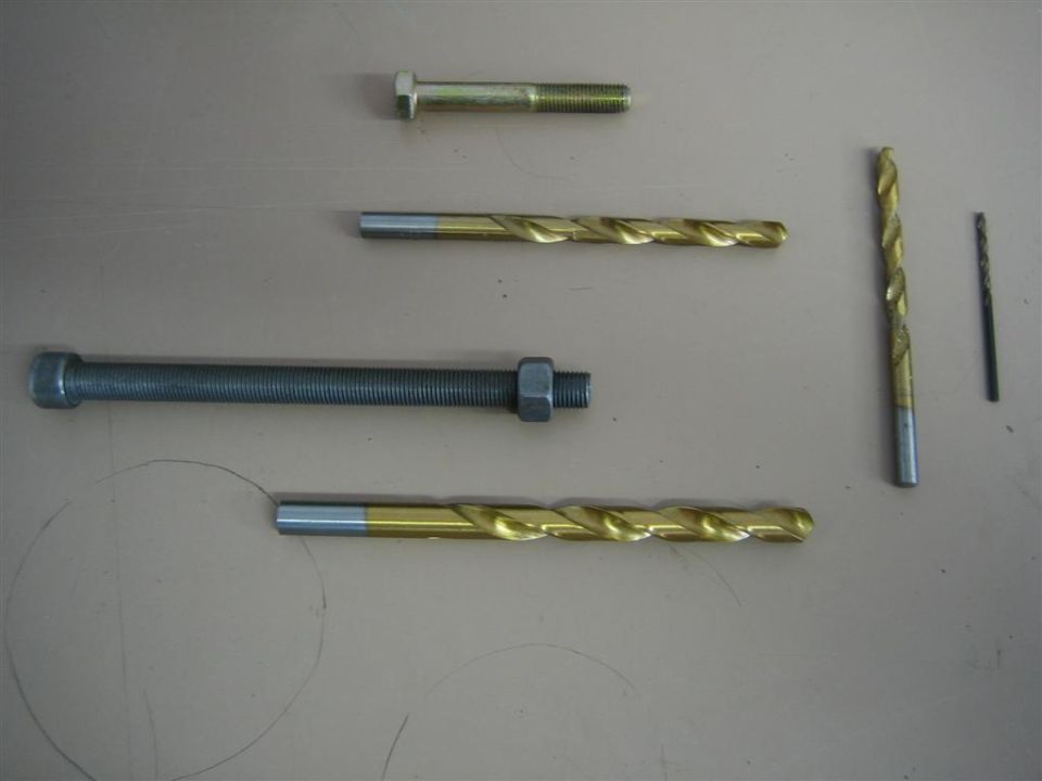 Bolts and drill bits on a surface. Includes a Supermotors.net logo