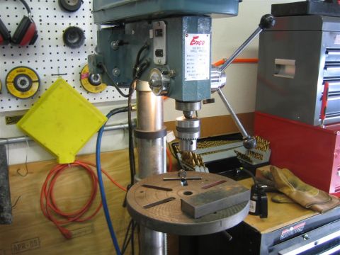 1987 Suzuki Samurai - A drill press is shown with a collection of drill bits and safety equipment on a workbench.