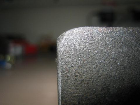1987 Suzuki Samurai - A close-up view of a textured metal component, possibly a vehicle part, with visible text at the bottom.