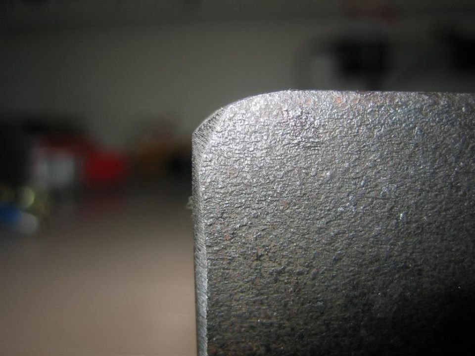 Close-up of a rough, textured metal part with a rounded edge. Text at the bottom reads 'SUPERMOTORS www.supermotors.net'