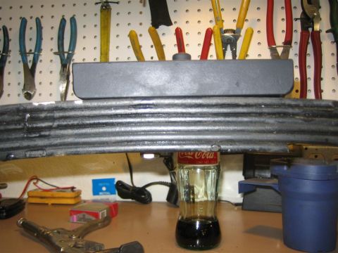 1987 Suzuki Samurai - A leaf spring is held up by a Coca-Cola bottle, with a shock absorber above it.