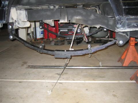 1987 Suzuki Samurai - Close-up view of a vehicle's rear leaf spring suspension system being worked on.