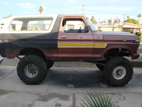 1979 Ford Bronco - This lifted Ford Bronco has a two-tone paint scheme and is sitting on large off-road tires.