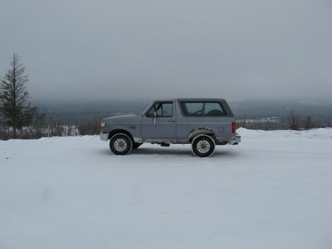 1994 Ford Bronco - A gray 1992 Ford Bronco sits on a snow-covered hill under an overcast sky.